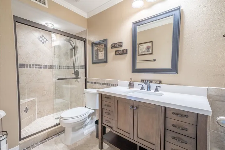 Bathroom 2 features a stylish vanity with storage, a mirror and downlight fixture, a ceramic tile floor and walk in shower.