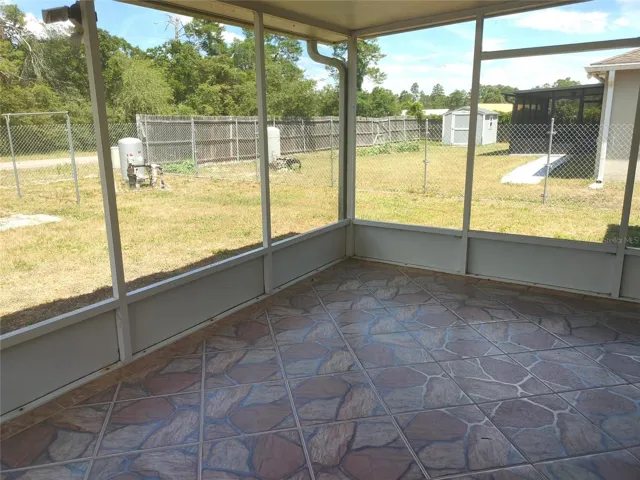 Tiled screened-in Lanai overlooks back wooded area