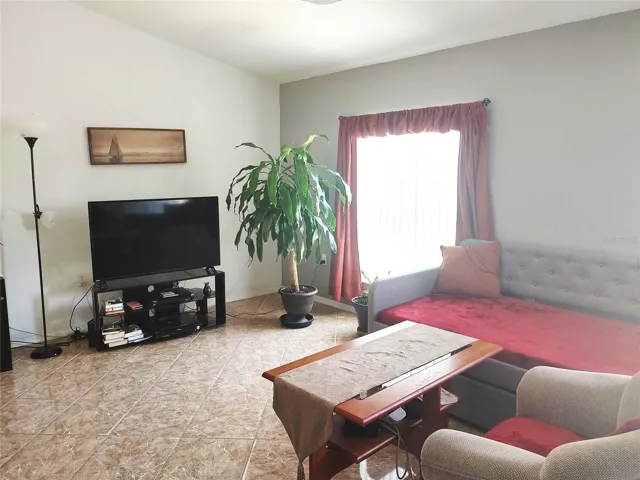 Vaulted ceilings, tiled floors in living area open to dining and kitchen are