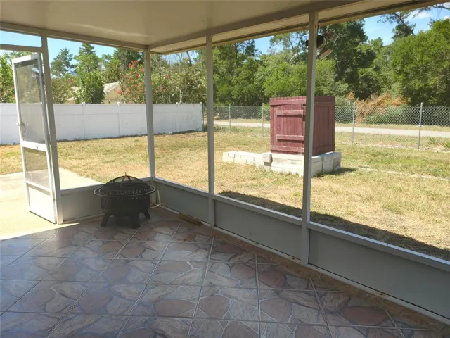 screened in lanai opens to cement patio for grilling. Smokehouse in back can be left if desired