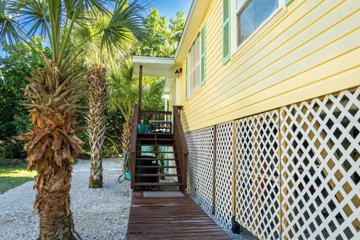 Stairs to front door/storage door beneath home