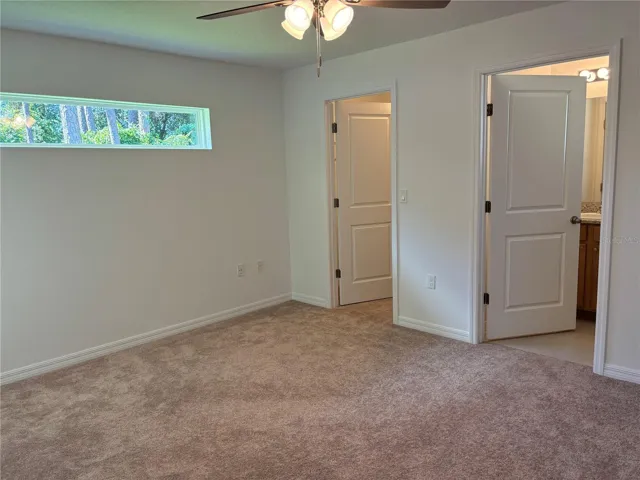 Large primary bedroom with walk in closet, en-suite bathroom. Transom window allows for natural light to shine through
