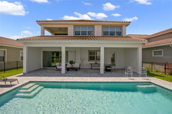 Swimming Pool overlooking back porch creating relaxing outdoor space
