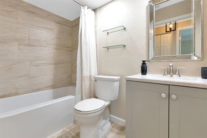 Remodeled guest bathroom with shower/tub combo and single sink with vanity.