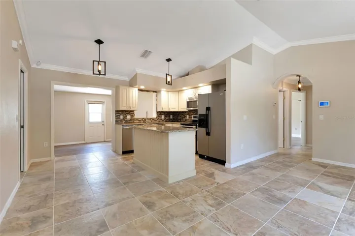 Island with cabinets, stainless steel appliances, and farmers sink.