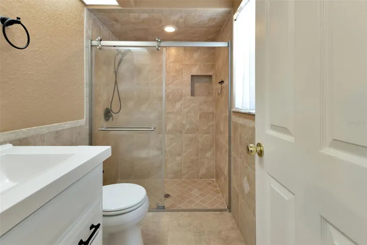 Master bathroom with walk in shower and single sink with vanity.