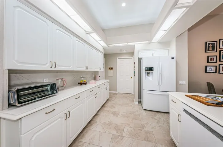 Light bright kitchen loaded with cabinets