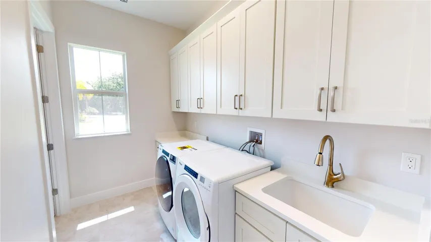 Laundry room with large walk-in storage closet