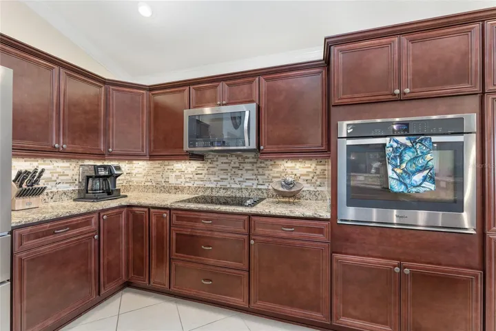 CHERRY CABINETRY, GRANITE COUNTERTOPS, LAZY SUSAN IN BOTTOM CORNER CABINET, WALL OVEN AND SEPARATE COOK TOP.