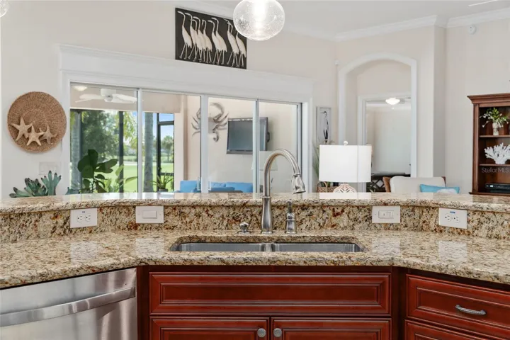 KITCHEN ISLAND OFFERS VIEW TO LIVING AREA, LANAI AND GOLF COURSE.