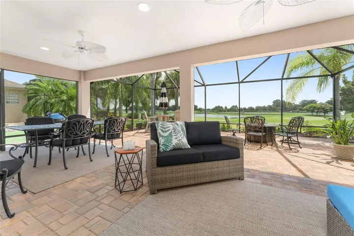 VIEW FROM PAVERED LANAI THROUGH BIRDCAGE TO LAKE AND GOLF. THREE REMOTE POWERED SCREENS BETWEEN THE LANAI AND THE BIRDCAGE CAN  BE CLOSED AS NEEDED TO KEEP THE ELEMENTS OUT OR FOR ADDED PRIVACY.
