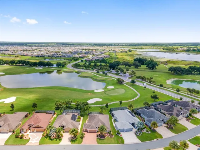 AERIAL SHOWS HOME (AT CENTER WITH PAVER DRIVEWAY), GOLF COURSE, LAKE , DOG PARK ACROSS THE ROAD BEHIND THE LAKE AND SHARON ROSE WEICHENS PRESERVE.