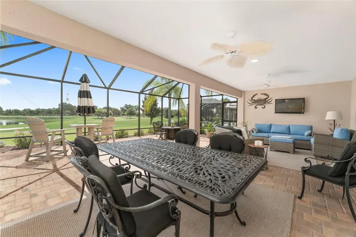 LANAI DINING AREA WITH VIEW TO GOLF AND LAKE IS OPEN TO BIRDCAGE ENCLOSED PATIO.  PAVERS THROUGHOUT THIS AREA.