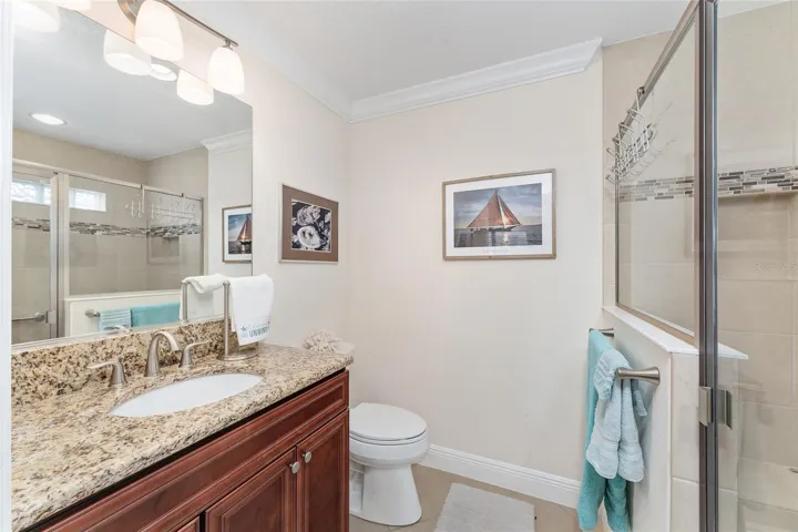 FRONT GUEST ROOM EN SUITE BATH NICELY FINISHED, INCLUDING CROWN MOLDING, GRANITE COUNTER AND CHERRY CABINETRY.