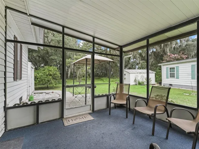 Looking out to BBQ spot, shed and wooded area