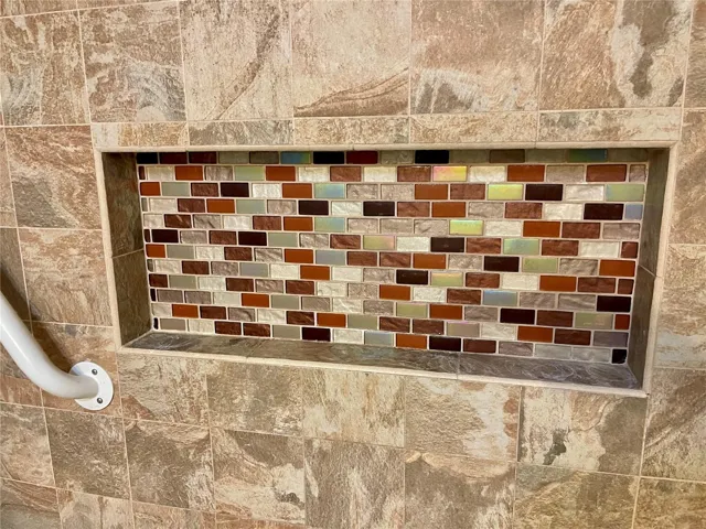 Deluxe tiled shampoo shelf in primary bedroom