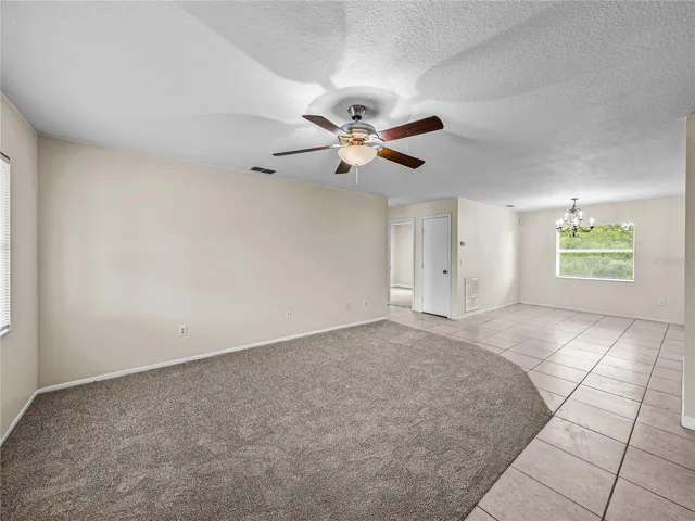 Living room with ceiling fan and ceramic tile in entry area