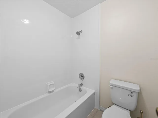 Primary bathroom with new tub surround & toilet