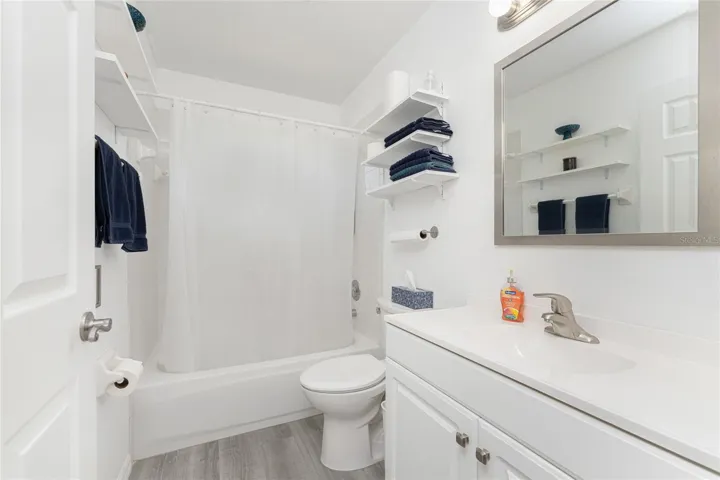Guest bathroom has an updated vanity with solid surface countertop.