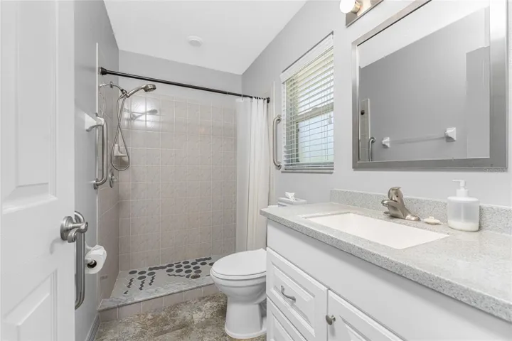 Master bathroom has a shower with grab bars, updated vanity with solid surface countertop and integrated sink, new medicine cabinet,  & new mirror.