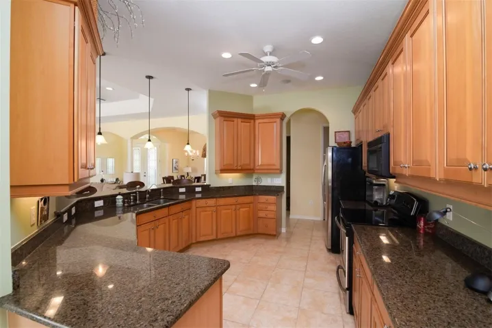 The kitchen features granite counters and ample maple cabinets with 42