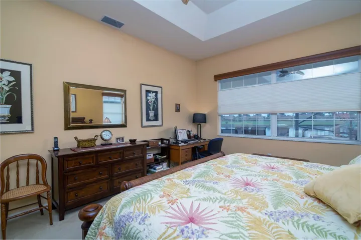 The primary bedroom has a large window area that looks out to the pool, pond and golf course.