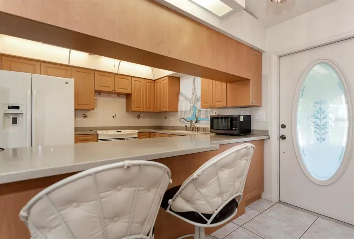 Nicely appointed breakfast bar kitchen that allows the cook to be a part of the party!