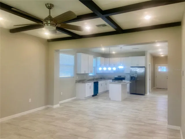 Open Great room with coffered ceiling, ceiling fan & led lights