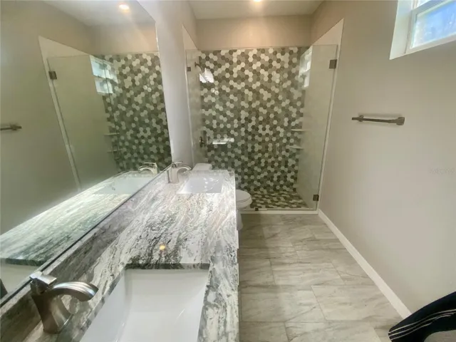 primary bath granite vanity & tiled walk in shower with glass door