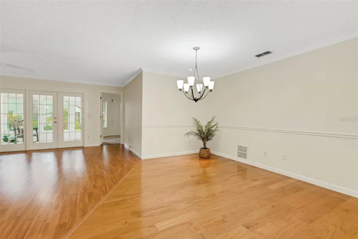 Open living and dining areas with French doors out to bonus sunroom~