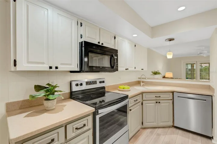 Updated kitchen with wood panel cabinets, solid surface counters & pantry closet~
