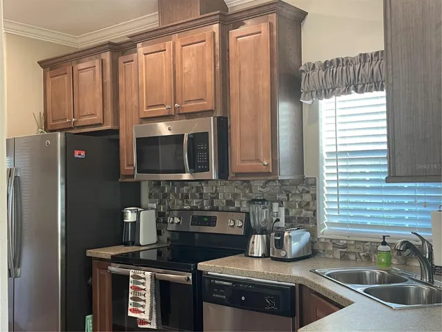 Kitchen features Side by side refrigerator, dishwasher, range and microwave.
