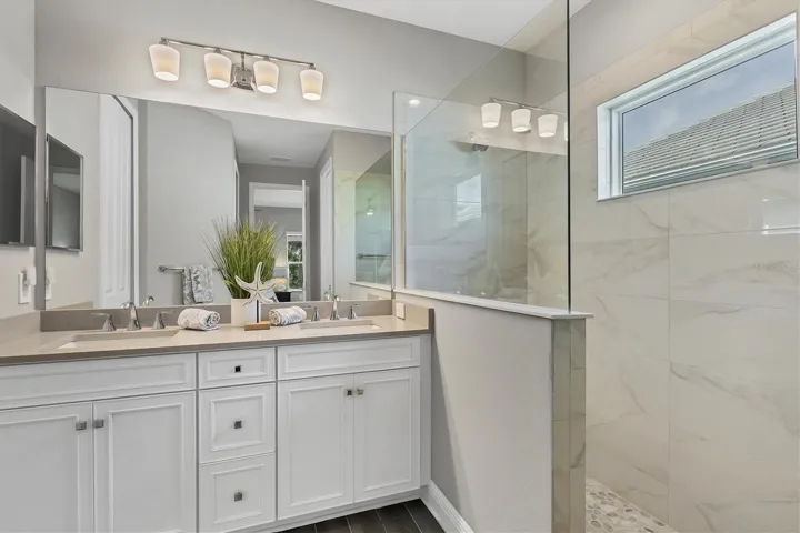 Primary bathroom with walk-in shower and double vanities