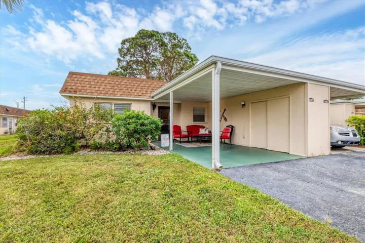 Front of villa with attached carport and storage closet