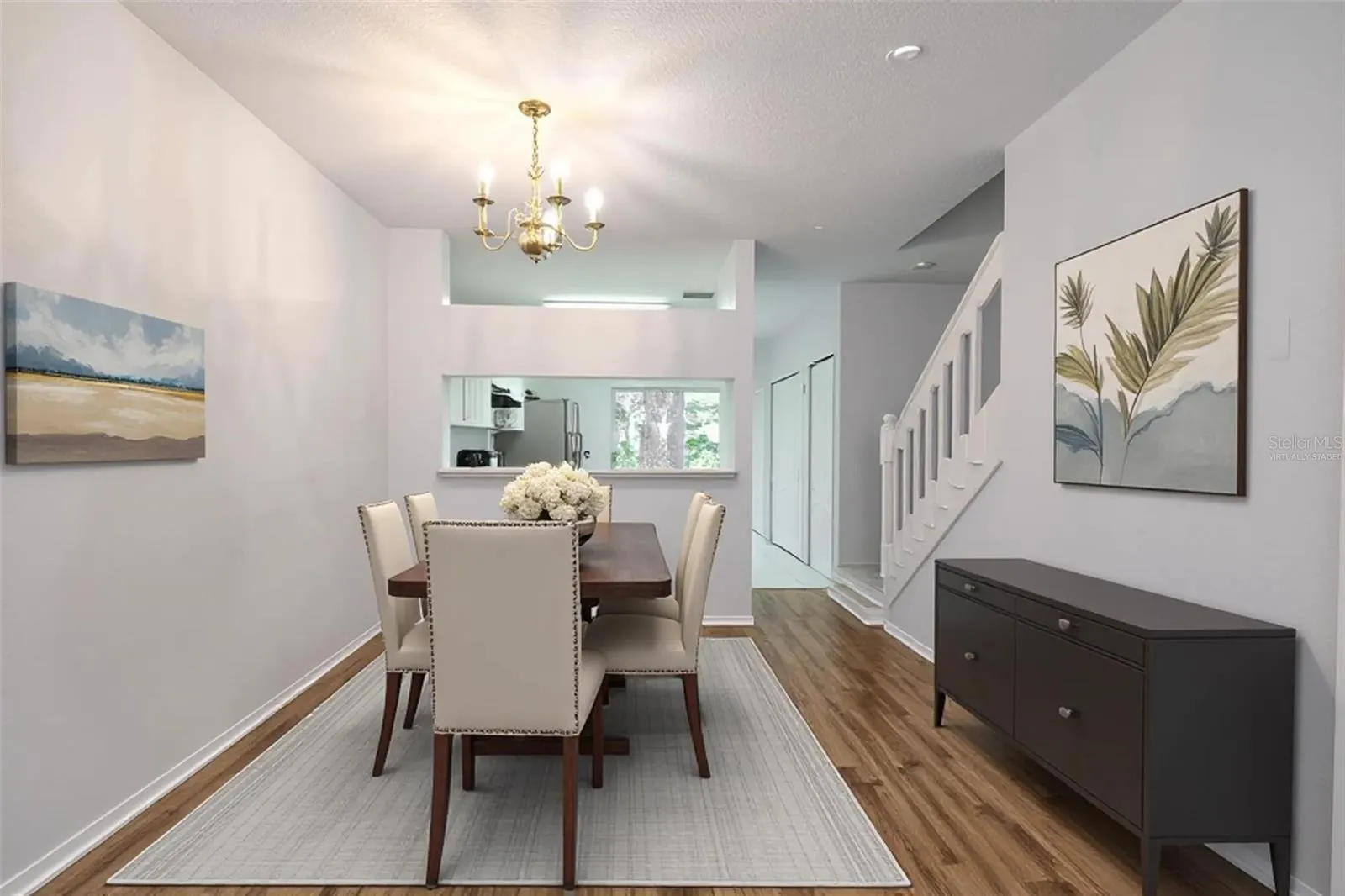 Dining room features wood laminate flooring, a 6 light chandelier and a convenient pass thru to the kitchen. (Photo has been virtually staged.)