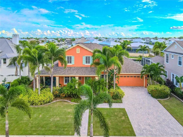 Waterfront, 5 Bedroom, 4 Bath, 3-Car Garage situated in a lush, tropical setting.