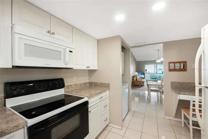 The kitchen features a smooth top electric range, built in microwave and dishwasher