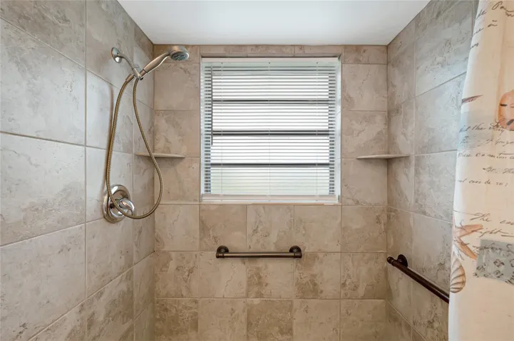 Updated primary bathroom with beautifully tiled shower