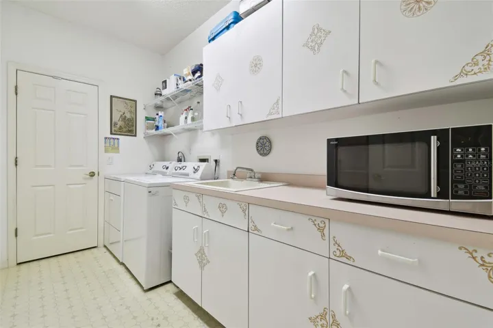 Laundry room with tub, private closet, many cabinets