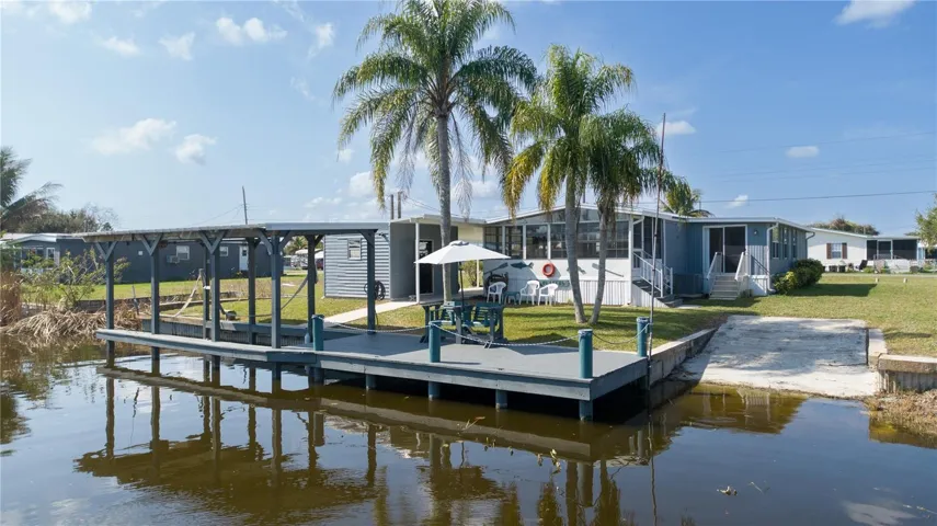 BACK CANAL VIEW OF HOME WITH BOATHOUSE AND RAMP