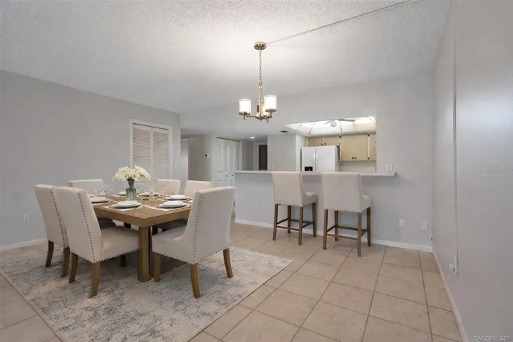 Virtually staged dining room showing breakfast bar with stools