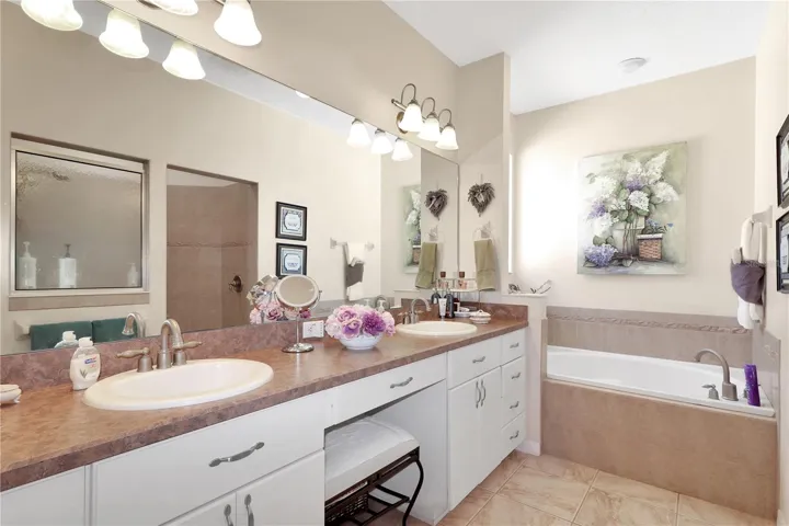 ensuite bath with a dual sink vanity and garden tub