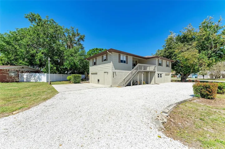 Circle driveway with a parking slab along with 2 garages. Entire first floor is hobby shop, garage, storage area, laundry, etc. Main living area is on second floor with a large front patio.