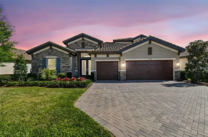 Fabulous curb appeal catches your attention, with meticulously maintained landscaping, stone facade, sealed paver driveway leading to a large, 3-car garage.