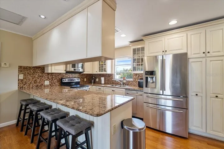 pacious kitchen with built-in cabinetry and open flow into the dining area, designed for comfortable island living.