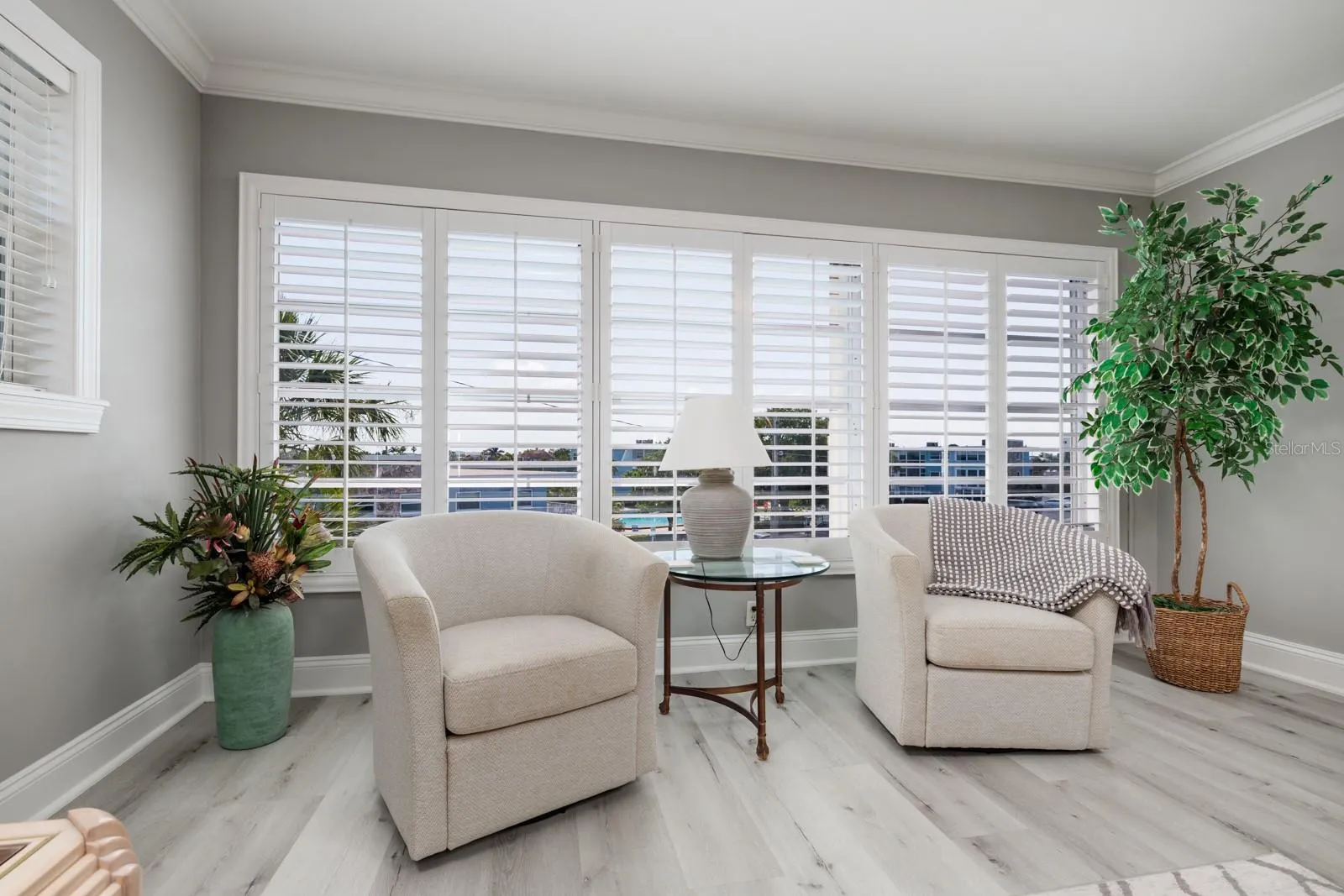 Large living room window w/pool &amp; bay views. Plantation shutters. Window faces southeast. Hurricane Shutter.