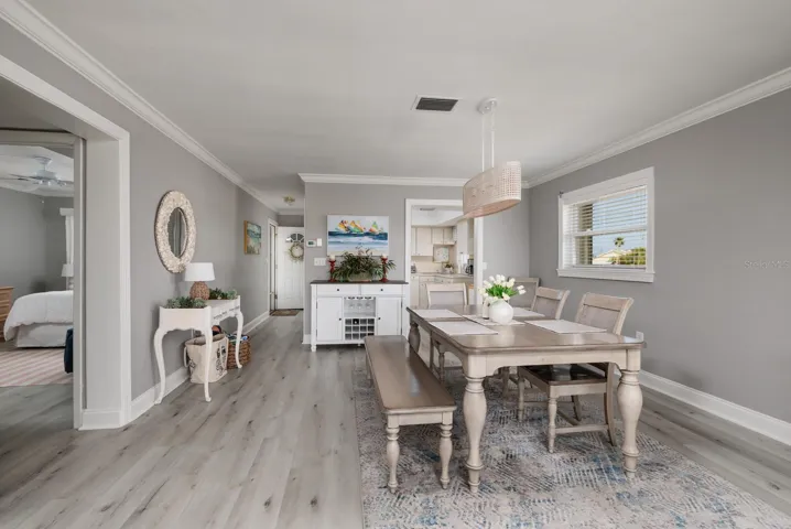 Dining area w/Crown Molding. Doorway to kitchen. 2nd bedroom  on left. Side window w/Hurricane shutter.