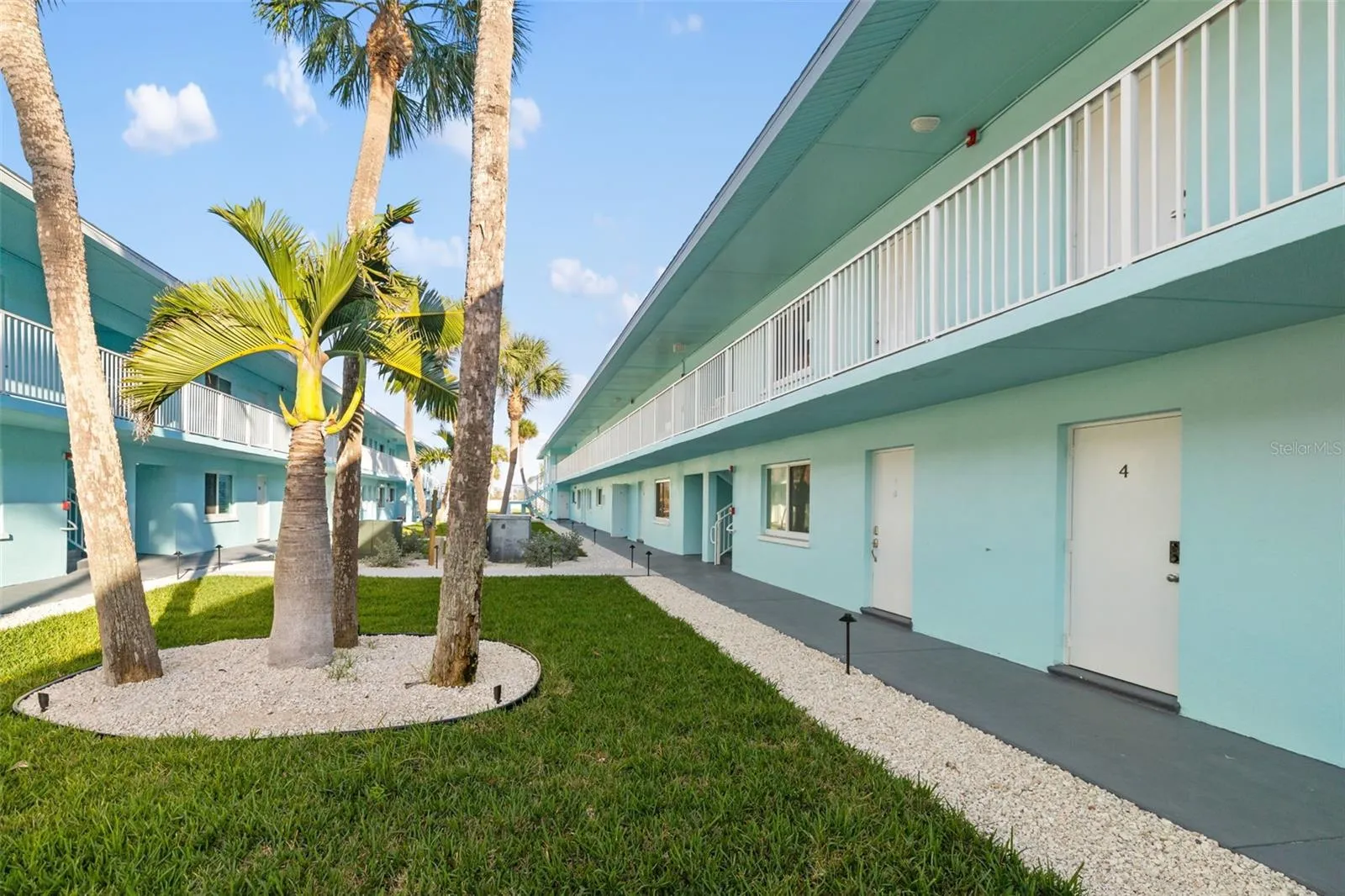 Tropical courtyard with landscaped grounds and walkway access to units.