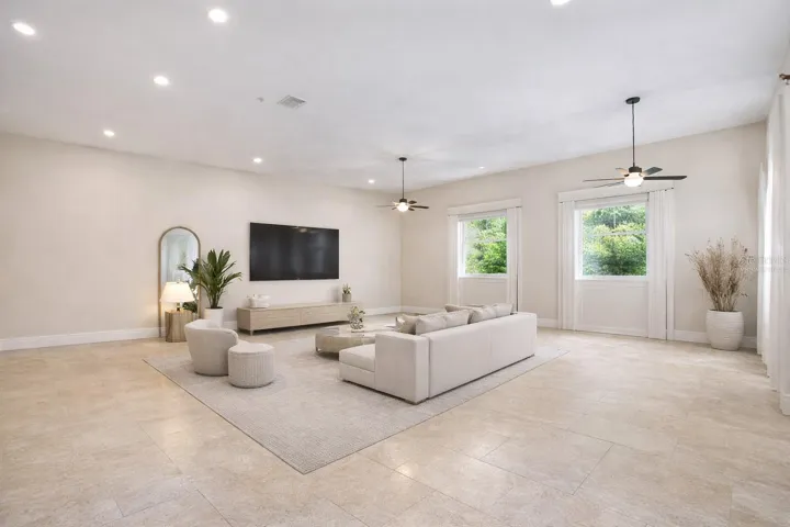 The expansive left wing includes a separate bedroom and bath offering a versatile space ready to be tailored to your family’s lifestyle. Whether envisioned as a guest retreat, home office, playroom, or multigenerational living area, the possibilities are truly endless. This photo has been virtually staged with out any kitchen elements. Seller will remove the kitchen with acceptable offer.