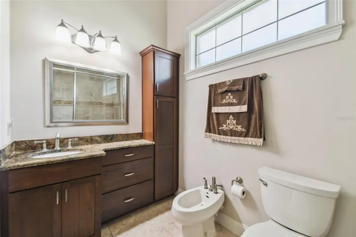Full bathroom with walk in shower and bidet connected to the media and game room.